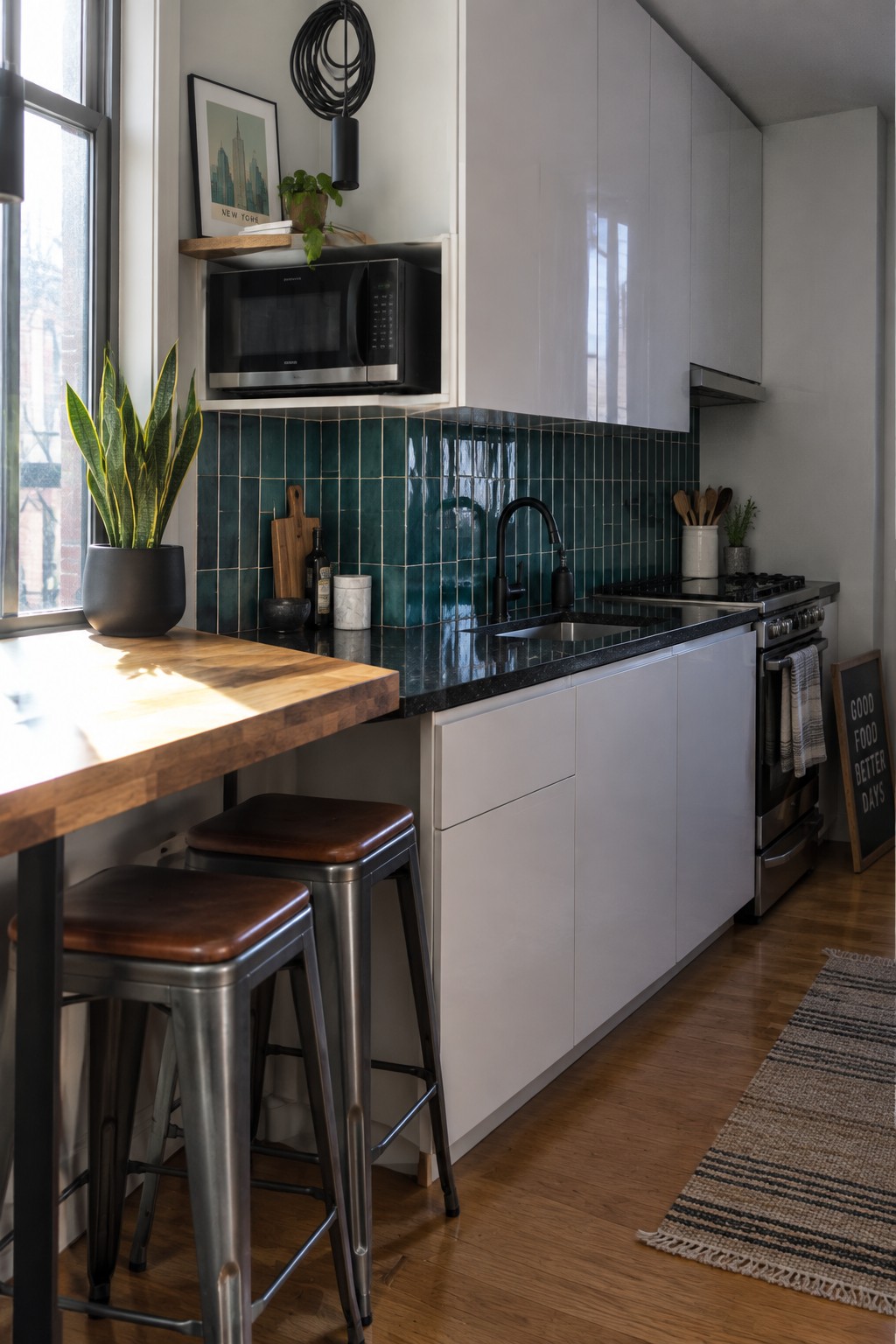 Modern kitchen with white cabinets, teal backsplash, black counter, and wooden bar stools
