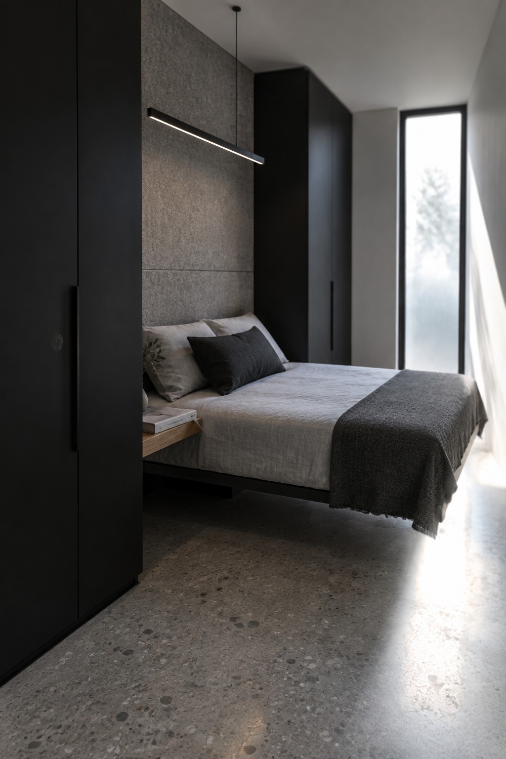 Minimalist bedroom with floating bed, gray linens, black cabinets, pendant light, concrete floor