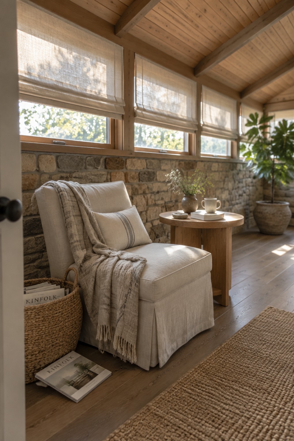 A laundry room with light wood cabinets and open shelves holding folded towels, a white washing machine, a stone countertop, and a white farmhouse sink with a black faucet.