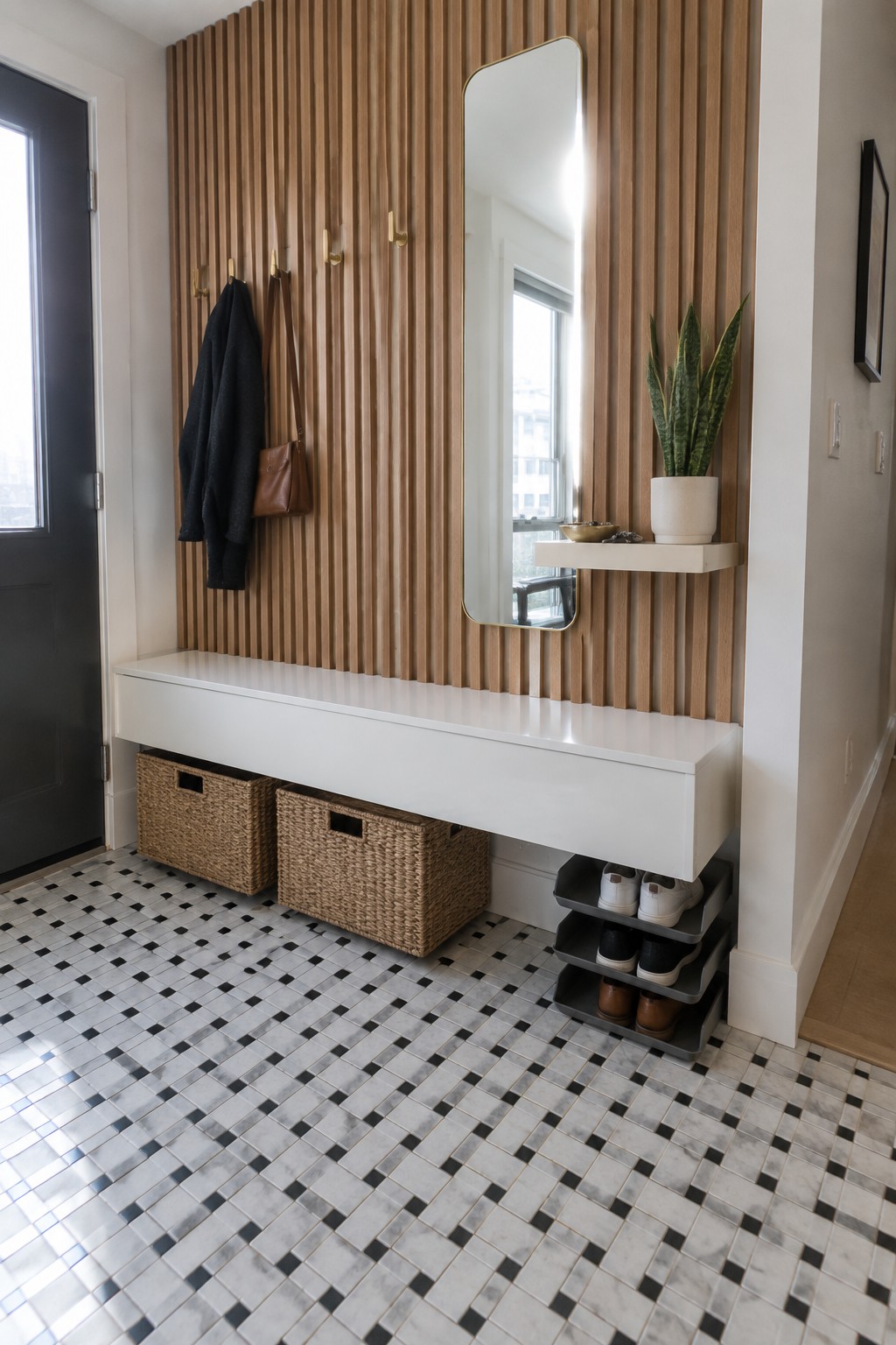 Modern mudroom with wood slat wall, white bench, mirror, baskets, and shoe rack