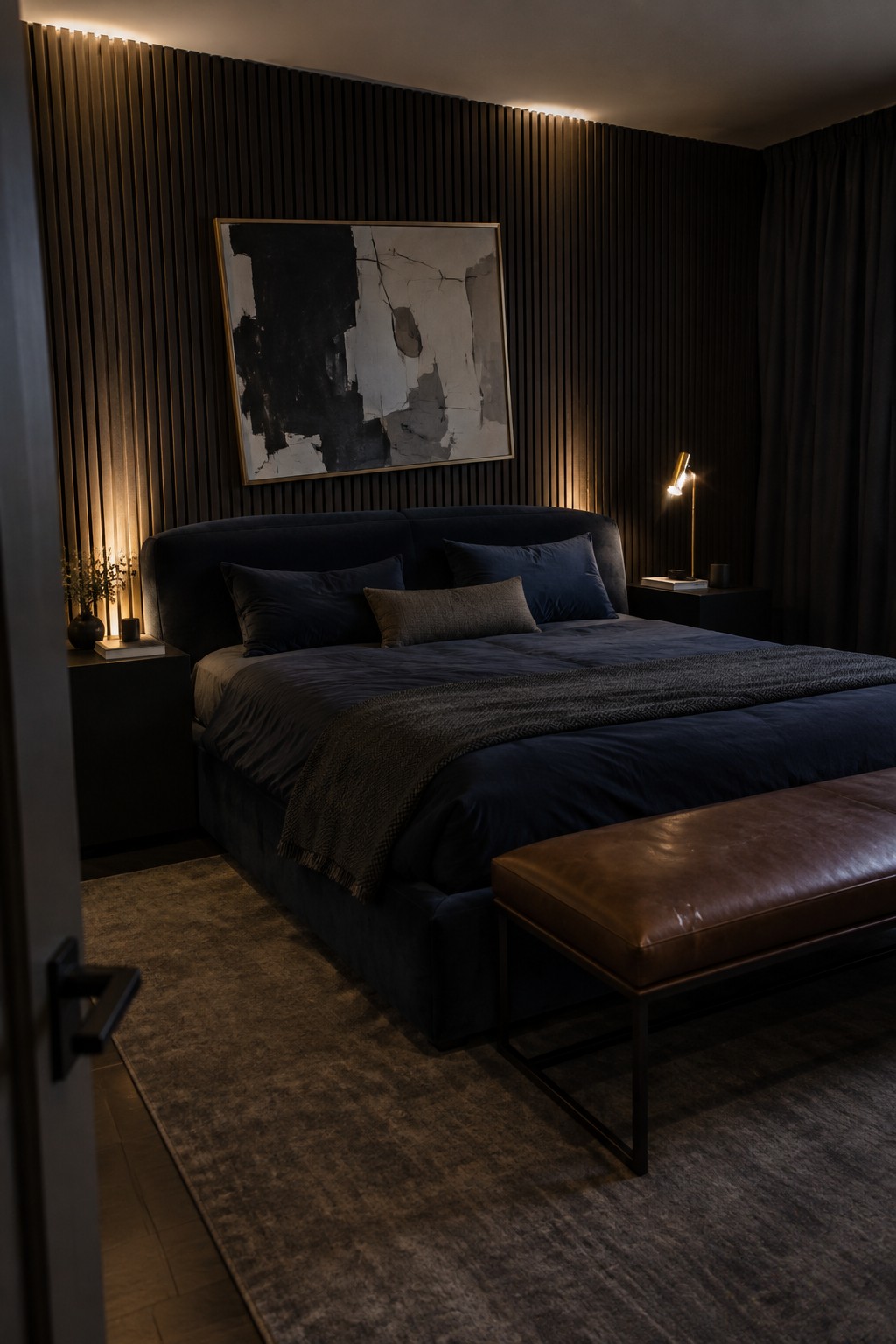 Dark moody bedroom with navy bed, abstract art on wood wall, leather bench