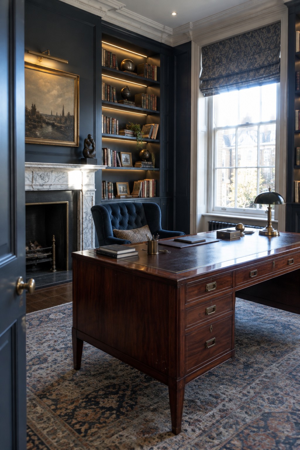 A traditional home library with dark wood paneling, a large wooden desk, and illuminated floor-to-ceiling bookshelves beside a marble fireplace.