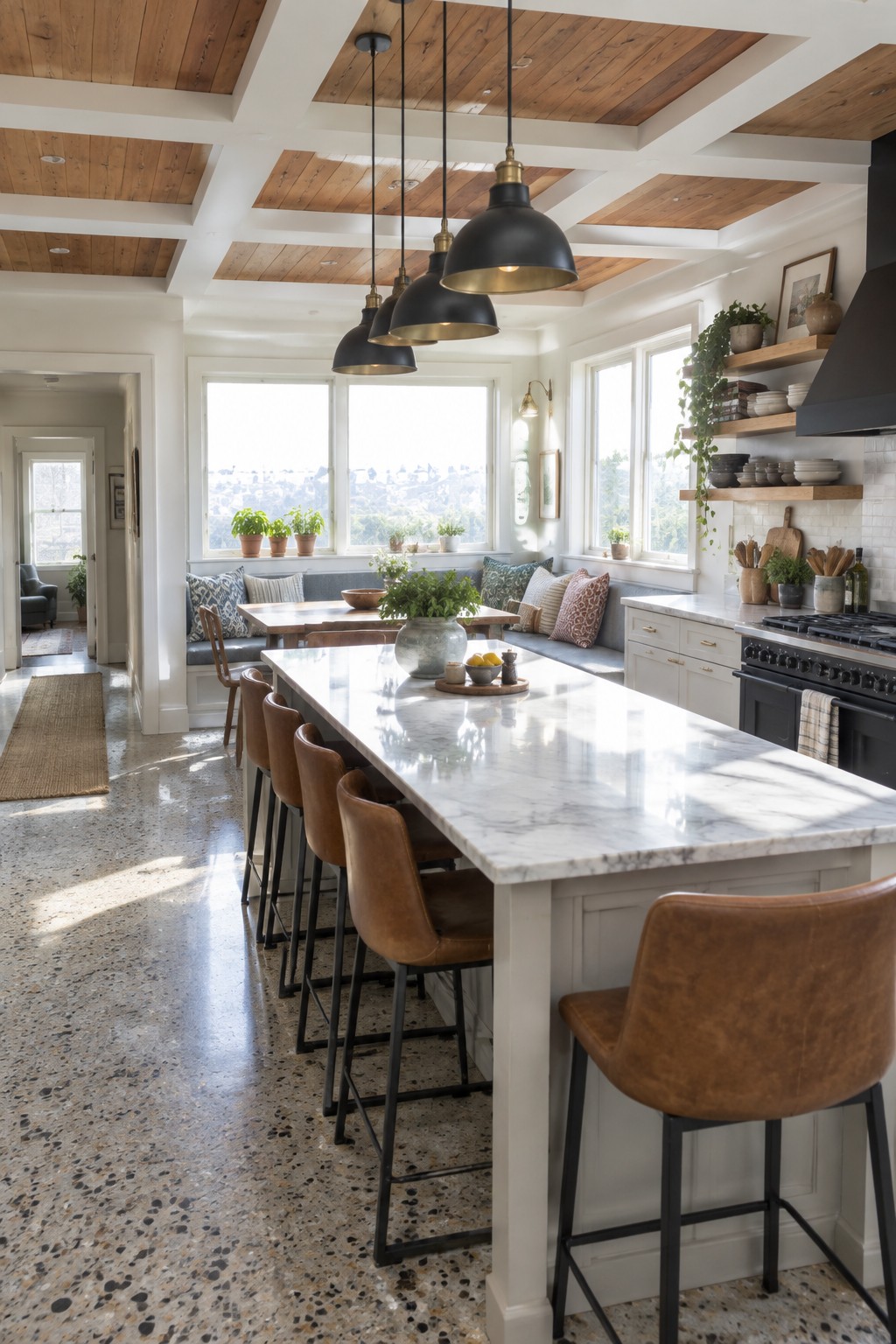 A bright kitchen with a white marble island, brown leather bar stools, and a ceiling of exposed wood beams and coffered panels.