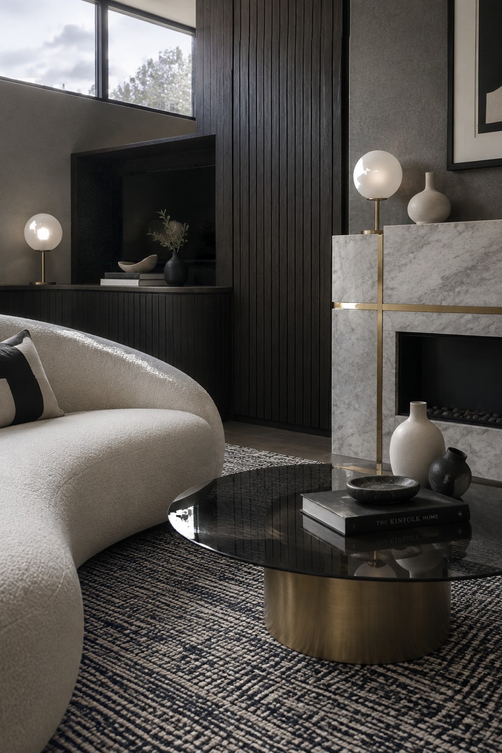 Modern living room with curved sofa, round coffee table, and marble fireplace.